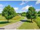 Scenic driveway leading to a house, framed by mature trees and well-manicured lawn, creating a private entrance at 226 Euharlee Five Forks Rd, Kingston, GA 30145