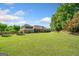 Expansive brick home featuring a manicured lawn, mature trees, and a charming picket fence under a blue sky at 226 Euharlee Five Forks Rd, Kingston, GA 30145