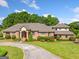 Stunning brick home with a well-manicured front lawn, circular driveway, and mature trees in the background at 226 Euharlee Five Forks Rd, Kingston, GA 30145