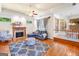 Cozy living room with fireplace, hardwood floors, large windows, and a blue sofa at 226 Euharlee Five Forks Rd, Kingston, GA 30145