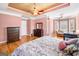 Main bedroom with hardwood floors, ceiling fan, tray ceiling, bay window, and fireplace at 226 Euharlee Five Forks Rd, Kingston, GA 30145