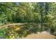 Serene pond reflecting surrounding trees and foliage, creating a tranquil and natural oasis at 226 Euharlee Five Forks Rd, Kingston, GA 30145
