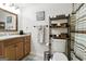 A compact bathroom featuring a single sink, a toilet, a shower with a curtain and a decorative rack at 136 Barrington Grange Dr, Sharpsburg, GA 30277