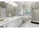 A spacious bathroom featuring double sinks, a soaking tub, a separate shower and tiled flooring at 136 Barrington Grange Dr, Sharpsburg, GA 30277