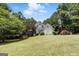 Charming two-story home with a lush lawn, mature trees and traditional architectural details at 136 Barrington Grange Dr, Sharpsburg, GA 30277