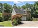 View of the side of the house with the garage and a long driveway, surrounded by trees at 136 Barrington Grange Dr, Sharpsburg, GA 30277