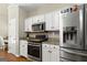 Modern kitchen with stainless steel appliances, granite countertops, and white cabinets for ample storage at 136 Barrington Grange Dr, Sharpsburg, GA 30277
