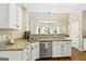 Modern kitchen featuring granite countertops, stainless steel appliances, and white cabinetry, offering a sleek and functional space at 136 Barrington Grange Dr, Sharpsburg, GA 30277