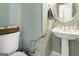Charming powder room with a pedestal sink, decorative accents, and unique wall decor, adding a touch of elegance at 136 Barrington Grange Dr, Sharpsburg, GA 30277