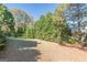 Green backyard with mature trees and landscaping at 214 Palette Ln, Peachtree City, GA 30269