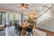 Bright dining room featuring hardwood floors, large windows, and an open concept layout to the kitchen and stairway at 214 Palette Ln, Peachtree City, GA 30269