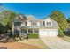 Charming two-story home with a two-car garage, blue front door, and well-maintained landscaping at 214 Palette Ln, Peachtree City, GA 30269