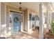 Close up of a light blue front door with decorative wreath and covered porch with outside seating at 214 Palette Ln, Peachtree City, GA 30269