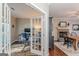 Well-lit home office with French doors, hardwood floors, and a view of the dining room and fireplace at 214 Palette Ln, Peachtree City, GA 30269