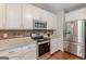 This kitchen features white cabinetry, stainless steel appliances, and granite countertops at 214 Palette Ln, Peachtree City, GA 30269