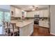 Well-lit kitchen with white cabinets, granite countertops, stainless steel appliances, and bar seating at the island at 214 Palette Ln, Peachtree City, GA 30269