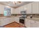 Modern kitchen featuring white cabinets, stainless steel appliances, granite countertops, and stylish backsplash at 214 Palette Ln, Peachtree City, GA 30269