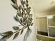 A decorative metal-leaf wall sculpture is displayed in the bathroom next to the shower-tub at 610 Tower Rd, Peachtree City, GA 30269