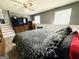 A bedroom with hardwood floors features a TV, ceiling fan, and staircase at 610 Tower Rd, Peachtree City, GA 30269
