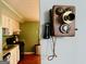 An antique phone graces the wall just outside of the kitchen area, blending nostalgia with modern living at 610 Tower Rd, Peachtree City, GA 30269