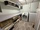 The laundry room features a washer, dryer, storage shelves, and hard wood flooring at 610 Tower Rd, Peachtree City, GA 30269