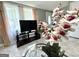 Bright living room showcasing a TV, sheer curtains, and a beautiful floral arrangement centerpiece at 610 Tower Rd, Peachtree City, GA 30269