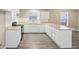 Bright kitchen features white cabinets, tile backsplash, stainless steel appliances, and durable modern flooring at 1159 Smith Sw St, Atlanta, GA 30310
