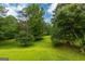 Expansive backyard featuring a lush lawn, mature trees, and a charming wooden bridge at 183 Inman Rd, Fayetteville, GA 30215