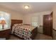 Charming bedroom with a wooden bed frame, patterned quilt, and matching side table at 183 Inman Rd, Fayetteville, GA 30215