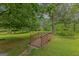 Charming small wooden bridge nestled in a green backyard, adding a unique landscape feature at 183 Inman Rd, Fayetteville, GA 30215