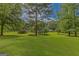 Spacious property with a lush green lawn, mature trees, and a charming outbuilding at 183 Inman Rd, Fayetteville, GA 30215
