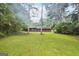 Lush backyard view featuring an expansive yard, mature trees, and natural landscape at 5618 Shadow Rock Dr, Lithonia, GA 30058