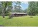 Well-maintained home with a sprawling lawn, covered porch, and mature trees providing ample shade at 5618 Shadow Rock Dr, Lithonia, GA 30058