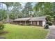 Inviting ranch-style home with a cozy front porch, lush lawn, and convenient driveway access at 5618 Shadow Rock Dr, Lithonia, GA 30058