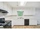 Traditional kitchen featuring white cabinets, laminate countertops, and a black electric cooktop at 5618 Shadow Rock Dr, Lithonia, GA 30058