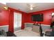 Comfortable bedroom with red walls, gray trim, and carpet floors, furnished with a desk and seating at 190 Country Club Dr, Hiram, GA 30141