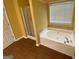 Bathroom featuring a tub, shower, vinyl flooring, and a window at 1472 Queenie Smith Ne Rd, Conyers, GA 30012