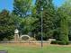 Welcoming River Club brick signage amidst lush landscaping, offering a glimpse of the serene community ambiance at 1472 Queenie Smith Ne Rd, Conyers, GA 30012