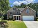 Charming two-story brick home features a well-manicured lawn and attached two-car garage at 1472 Queenie Smith Ne Rd, Conyers, GA 30012