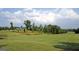 Expansive green golf course with trees and a distant white building under a blue sky at 1472 Queenie Smith Ne Rd, Conyers, GA 30012
