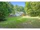 Expansive backyard featuring a deck, lush green lawn, and wooded surroundings at 419 Jeffery Dr, Locust Grove, GA 30248
