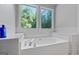 Relaxing bathroom with a jetted tub and a picturesque wooded view at 419 Jeffery Dr, Locust Grove, GA 30248