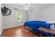 Well-lit bedroom featuring wood floors, ceiling fan, and a large window at 419 Jeffery Dr, Locust Grove, GA 30248