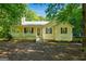 Charming yellow home with a welcoming front porch and mature trees providing shade at 419 Jeffery Dr, Locust Grove, GA 30248