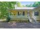 Inviting covered porch with white railing, steps to the yard, and shade trees at 419 Jeffery Dr, Locust Grove, GA 30248
