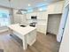Modern kitchen with white cabinets, stainless steel appliances, and an island with a sink and sleek countertops at 485 West Ave, Bowdon, GA 30108
