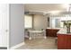Bright bathroom featuring a tiled tub, window, wooden cabinets and a marble countertop at 1252 Heritage Dr, Villa Rica, GA 30180