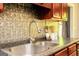 Close-up of the kitchen sink, showcasing a tile backsplash and granite countertops at 1252 Heritage Dr, Villa Rica, GA 30180