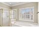 Bathroom with walk-in shower, tub, and large window at 914 Champions Way, Mcdonough, GA 30252