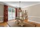 Dining room features hardwood floors, glass table with decorative base and elegant chandelier at 914 Champions Way, Mcdonough, GA 30252